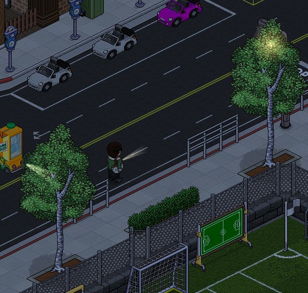 La avenida de noche con faroles y la cancha iluminada